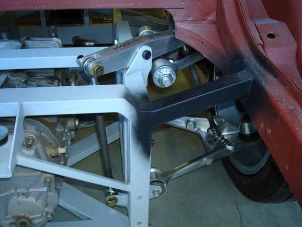 Rear suspension showing mock-up shock &quot;rocker&quot; and attendant strut rods.  The proper rocker will have an offset fulcrum to allow greater motion without contacting the frame at either side of the rocker.  This arrangement helps reduce unsprung weight and provides clearance for the halfshaft.