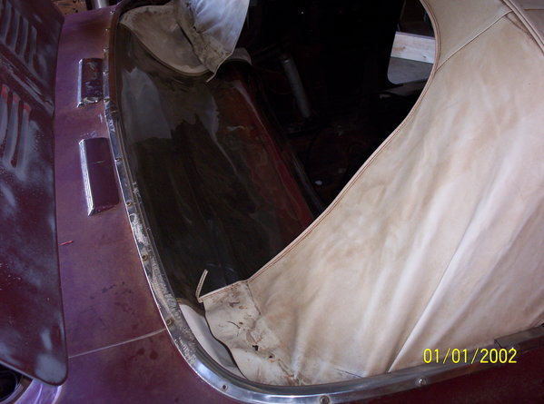 The back curtain area is pulled away.  The plastic window is intact, but due to the stretching, it cannot be zipped.  The trim sticks which hold the top to the back wall, are loose and missing bolts in a few places as well